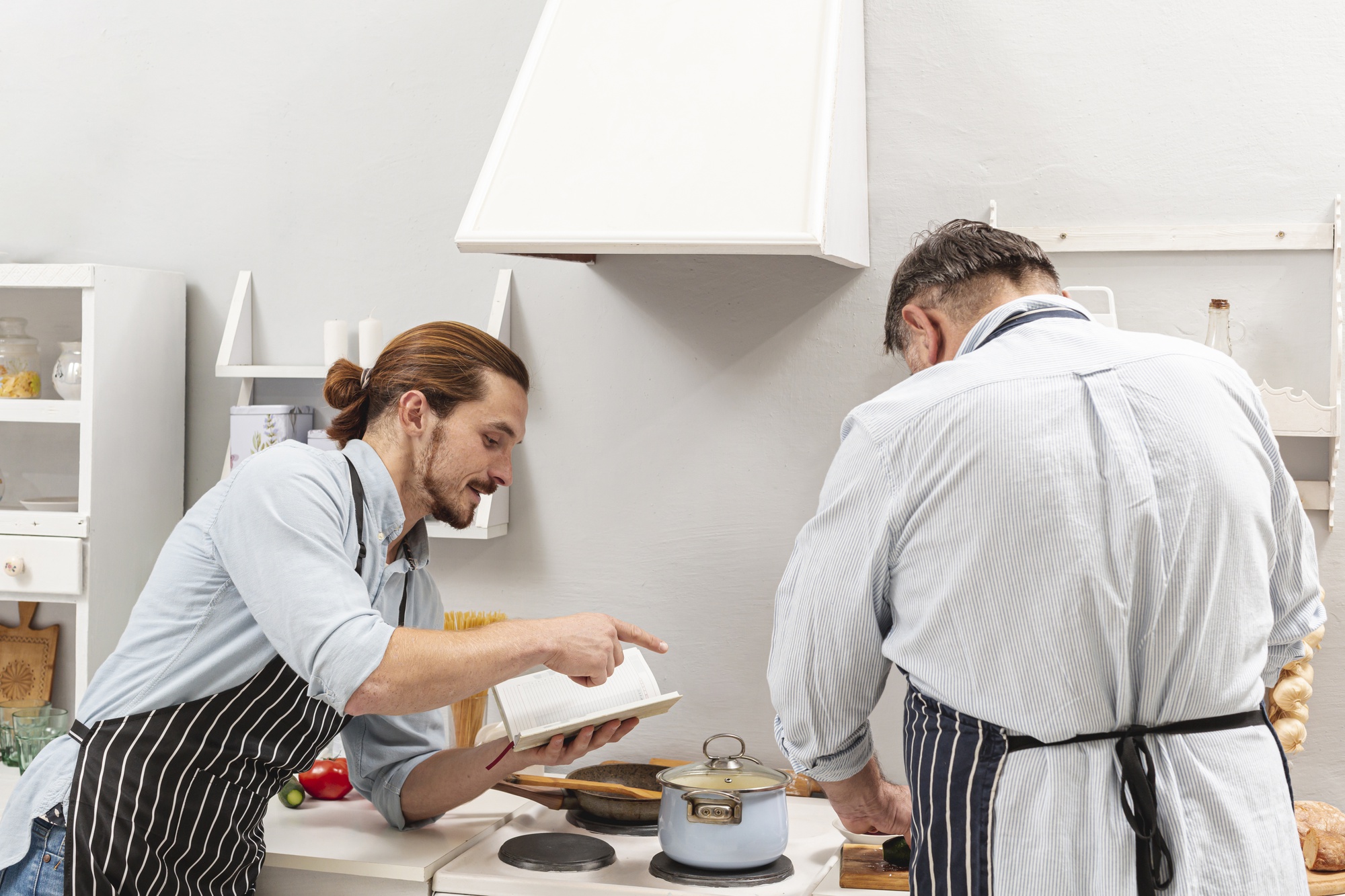 Instructor guiding student at stove